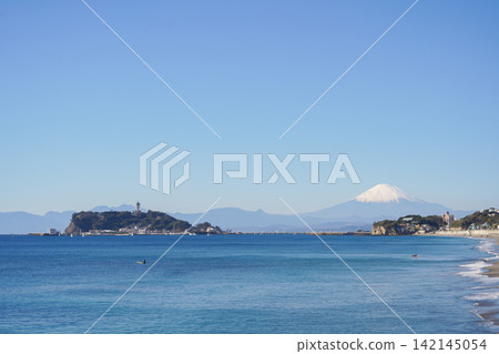 Enoshima Island and snow-capped Mount Fuji as seen across the blue sea. Enoshima Island and snow-capped Mount Fuji as seen across the blue sea. 142145054
