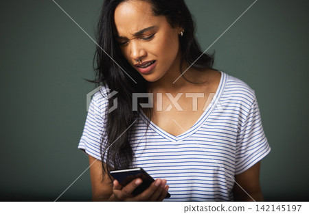 Confused, smartphone and woman in studio for scam, phishing or fake news on green background. Communication, annoyed and person on mobile phone for internet problem, spam email or negative text Confused, smartphone and woman in studio for scam, phishing or fake news on green background. Communication, annoyed and person on mobile phone for internet problem, spam email or negative text 142145197