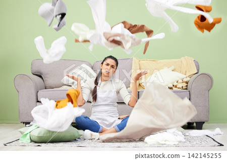 Woman, home and laundry with stress, chaos and portrait by sofa on floor in living room for hygiene. Frustrated girl, person and throw clothes on carpet, apron and cleaning with housework in lounge Woman, home and laundry with stress, chaos and portrait by sofa on floor in living room for hygiene. Frustrated girl, person and throw clothes on carpet, apron and cleaning with housework in lounge 142145255