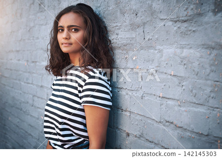 Brick, wall background and portrait of girl in city with fashion, trendy clothes and casual style. Student, college and woman in urban town with confidence, pride and attitude outdoors on weekend 142145303