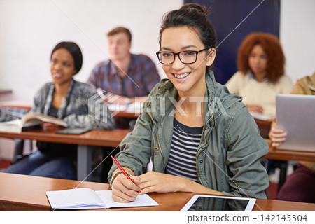 Classroom, student and portrait with smile in university for answer, information and education. College, girl and students on campus for studying, writing and learning with books or tech for quiz Classroom, student and portrait with smile in university for answer, information and education. College, girl and students on campus for studying, writing and learning with books or tech for quiz 142145304