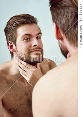 Man, mirror and skincare with beard, face and skin for grooming, self care and routine with a smile. Cosmetic, dermatology and reflection or male person, wellness and happy with treatment at home Man, mirror and skincare with beard, face and skin for grooming, self care and routine with a smile. Cosmetic, dermatology and reflection or male person, wellness and happy with treatment at home 142145582