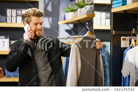 Businessman, phone call and shopping in boutique for outfit, fashion and clothes in shop for sale. Male person, communication and customer in store for retail, networking and thrifting in New York Businessman, phone call and shopping in boutique for outfit, fashion and clothes in shop for sale. Male person, communication and customer in store for retail, networking and thrifting in New York 142145592