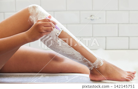 Person, leg and shave with razor in bathroom for hair removal in tub or treatment, cleaning or skincare. Hand, cream and morning routine in home for smooth results or cosmetic, self care or beauty Person, leg and shave with razor in bathroom for hair removal in tub or treatment, cleaning or skincare. Hand, cream and morning routine in home for smooth results or cosmetic, self care or beauty 142145751