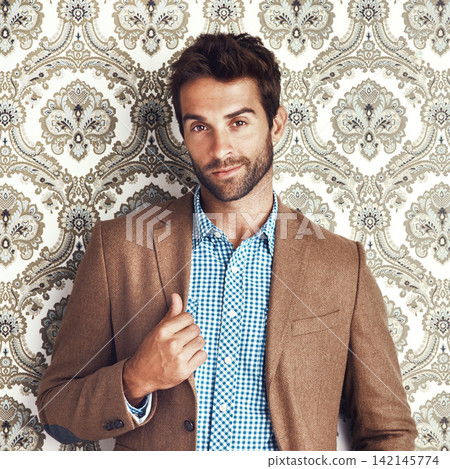 Portrait, confidence and man in suit on a wallpaper background isolated in studio for vintage fashion. Face, style and person in clothes, blazer and retro pattern of classy model in Switzerland Portrait, confidence and man in suit on a wallpaper background isolated in studio for vintage fashion. Face, style and person in clothes, blazer and retro pattern of classy model in Switzerland 142145774