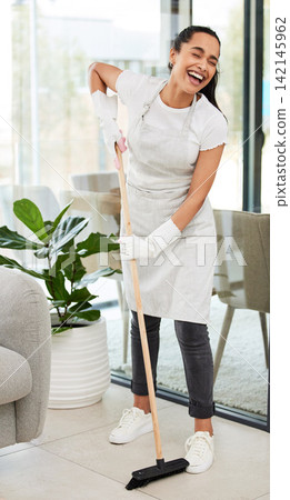 Happy woman, housekeeping and sweeping with broom for cleaning floor, dirt or dusty surface at home. Female person, cleaner or young maid with smile for neat and tidy living room, apartment or house Happy woman, housekeeping and sweeping with broom for cleaning floor, dirt or dusty surface at home. Female person, cleaner or young maid with smile for neat and tidy living room, apartment or house 142145962