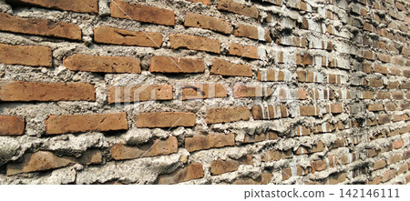 Rough red brick wall with traces of cement mortar. Rough red brick wall with traces of cement mortar. 142146111
