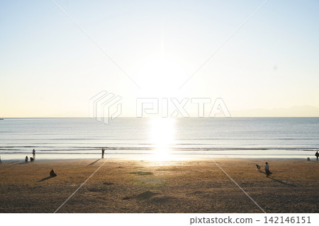 People enjoying the golden sunset from the sandy beach of Enoshima. People enjoying the golden sunset from the sandy beach of Enoshima. 142146151