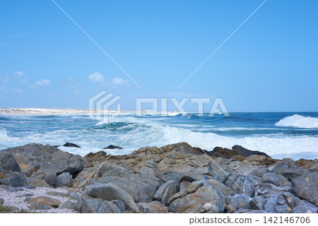 Ocean, waves and rocks on coast of beach in Malaysia for outdoor travel in summer for vacation or holiday. Sea, stone and blue sky with landscape for wallpaper or background, water and nature. Ocean, waves and rocks on coast of beach in Malaysia for outdoor travel in summer for vacation or holiday. Sea, stone and blue sky with landscape for wallpaper or background, water and nature. 142146706