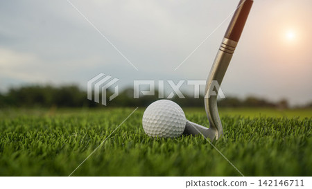 Golf clubs and balls on a green lawn in a beautiful golf course with morning sunshine. Golf clubs and balls on a green lawn in a beautiful golf course with morning sunshine. 142146711