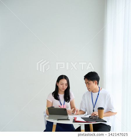 Young men and women working in casual attire 142147025