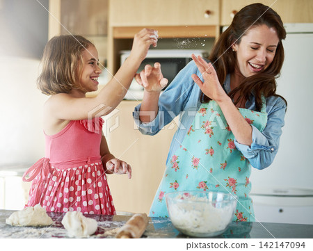 Mother, child and playful baking with dough for homemade cookies at home, bonding or dessert. Woman, daughter and laughing in kitchen while learning for cooking education or pastry, morning or flour Mother, child and playful baking with dough for homemade cookies at home, bonding or dessert. Woman, daughter and laughing in kitchen while learning for cooking education or pastry, morning or flour 142147094