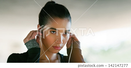 Fitness, focus and woman with earphones for streaming music, listening to podcast or radio station. Serious, sport and female athlete for running, morning workout or cardio exercise on banner Fitness, focus and woman with earphones for streaming music, listening to podcast or radio station. Serious, sport and female athlete for running, morning workout or cardio exercise on banner 142147277