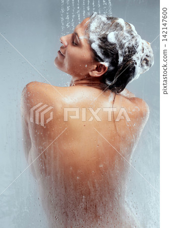 Shampoo, studio or woman in shower for body hygiene, skincare and washing with wellness or water. Back, grey background and wet girl cleaning with soap and liquid for beauty, health and hair care Shampoo, studio or woman in shower for body hygiene, skincare and washing with wellness or water. Back, grey background and wet girl cleaning with soap and liquid for beauty, health and hair care 142147600