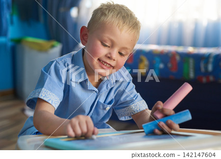 Home, boy and writing on chalkboard, education and fun activity with creativity or artwork. Child development, house and kid with idea or smile with student or hobby for learning, drawing or carefree Home, boy and writing on chalkboard, education and fun activity with creativity or artwork. Child development, house and kid with idea or smile with student or hobby for learning, drawing or carefree 142147604