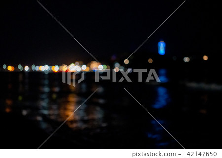 A night view of a harbor across the sea, with bokeh effect. A night view of a harbor across the sea, with bokeh effect. 142147650
