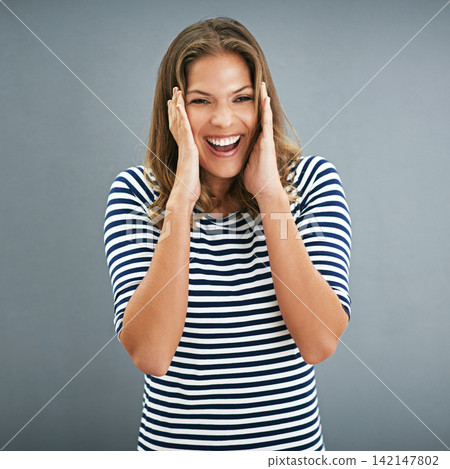 Woman, portrait and excitement with studio, ears covered and celebration for winner. Model, smile and happiness for good news, promotion and achievement with victory isolated on grey background Woman, portrait and excitement with studio, ears covered and celebration for winner. Model, smile and happiness for good news, promotion and achievement with victory isolated on grey background 142147802