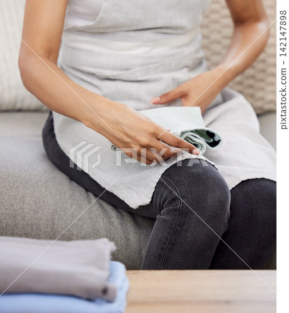 Woman, hands and folding with laundry on sofa for clean clothing, chores or housekeeping at home. Closeup of female person, cleaner or maid with dry washing for neat and tidy apartment or house Woman, hands and folding with laundry on sofa for clean clothing, chores or housekeeping at home. Closeup of female person, cleaner or maid with dry washing for neat and tidy apartment or house 142147898