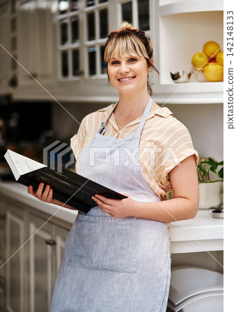 Woman, portrait and recipe book in kitchen for cooking food, happiness and apron for cake for cookies or baker. Chef, smile and baking for diet at home, health and nutrition or meal with ingredients Woman, portrait and recipe book in kitchen for cooking food, happiness and apron for cake for cookies or baker. Chef, smile and baking for diet at home, health and nutrition or meal with ingredients 142148133
