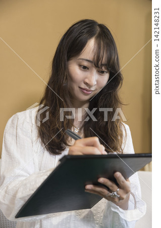 A young woman filling out a medical questionnaire at a salon. A young woman filling out a medical questionnaire at a salon. 142148231