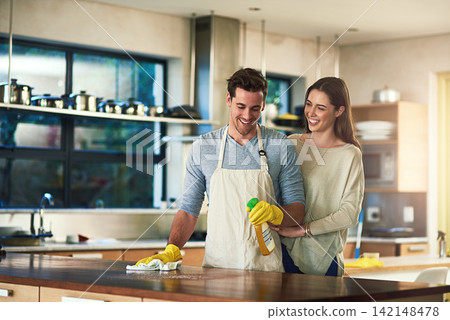 Smile, couple and help with cleaning in kitchen for hygiene, disinfection or maintenance in marriage. Man, woman and happy with equipment at home for bacteria removal, care or support in housekeeping Smile, couple and help with cleaning in kitchen for hygiene, disinfection or maintenance in marriage. Man, woman and happy with equipment at home for bacteria removal, care or support in housekeeping 142148478