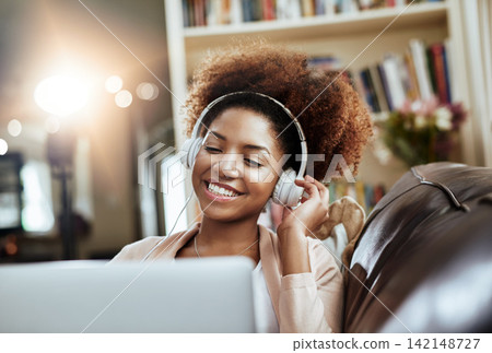 Smile, laptop and woman on sofa with headphones, relax and happy morning streaming in living room. Rest, wellness and girl on couch in home with online music, digital app and computer in apartment. Smile, laptop and woman on sofa with headphones, relax and happy morning streaming in living room. Rest, wellness and girl on couch in home with online music, digital app and computer in apartment. 142148727