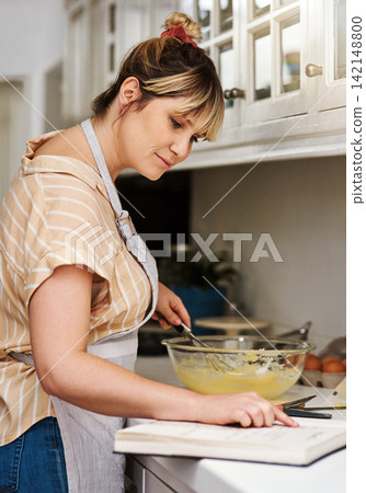 Baking, book and recipe with woman in kitchen of home for guide, instructions or reading steps. Cooking, food and small business bakery with entrepreneur chef at counter of apartment for startup Baking, book and recipe with woman in kitchen of home for guide, instructions or reading steps. Cooking, food and small business bakery with entrepreneur chef at counter of apartment for startup 142148800