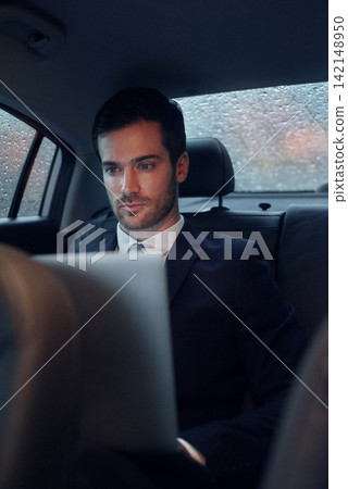 Businessman, car and laptop for transportation travel to work meeting or airport, raining or commute. Male person, backseat and entrepreneur for tech company or city chauffeur for trip, cab or taxi Businessman, car and laptop for transportation travel to work meeting or airport, raining or commute. Male person, backseat and entrepreneur for tech company or city chauffeur for trip, cab or taxi 142148950