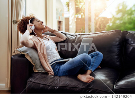 Relax, laptop and woman on sofa with headphones, smile and happy morning streaming in living room. Rest, wellness and girl on couch in home with online music, digital app and computer in apartment. Relax, laptop and woman on sofa with headphones, smile and happy morning streaming in living room. Rest, wellness and girl on couch in home with online music, digital app and computer in apartment. 142149204