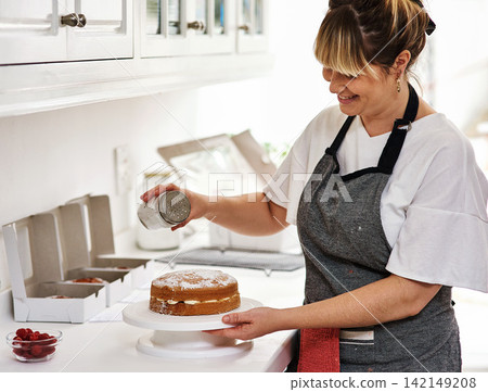 Cake, decoration and woman with icing sugar in kitchen for bakery, preparation and creativity in food. Snack, sweet and baker with dessert on table for small business, pastry shop and confectionery 142149208