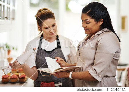 People, notes or teamwork for cooking recipe, talking or meal ingredients in house kitchen for menu. Startup, women or bakers with notebook in discussion, communication or conversation for business 142149481