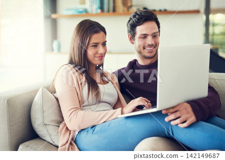 Laptop, love and couple on sofa in living room browsing for movie, show or film together at home. Happy, technology and people relaxing and streaming funny, comic or comedy video on computer at house 142149687