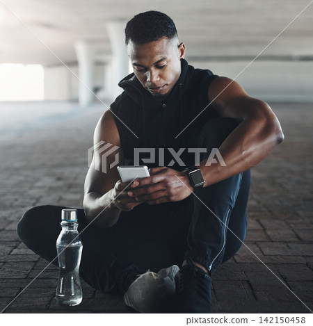 Black man, phone and break from exercise in city with texting, reading or relax on ground with fitness. Male person, smartphone and runner with contact, app or social media on concrete in New York Black man, phone and break from exercise in city with texting, reading or relax on ground with fitness. Male person, smartphone and runner with contact, app or social media on concrete in New York 142150458