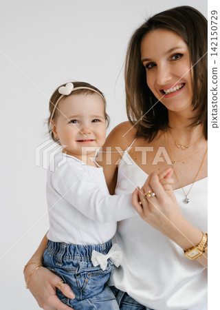 Smiling Mother Holding Hand of Small Daughter Smiling Mother Holding Hand of Small Daughter 142150729