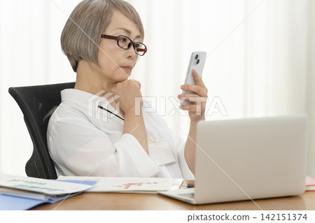 在辦公室工作的老年女性 在辦公室工作的老年女性 142151374