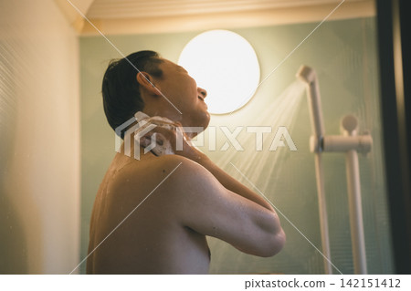 A man's bath time, focusing on washing his neck. A man's bath time, focusing on washing his neck. 142151412
