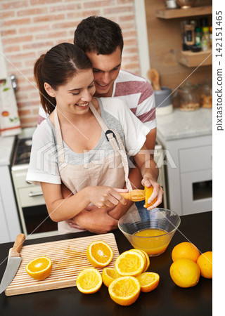 Couple, hug and fruit in orange juice with smile, health and wellness in winter or season. Man, woman and cheerful in preparing citrus for nutrition, vitamin c and diet for fresh, squeezed and drink 142151465