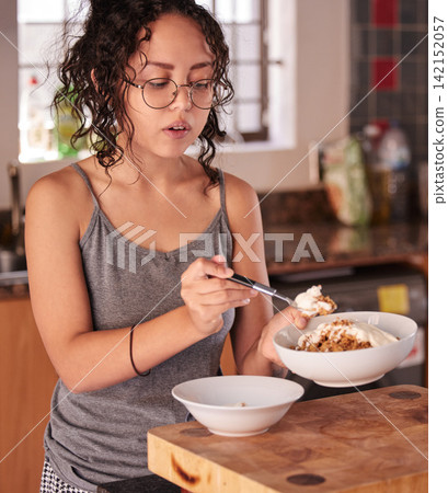Girl, breakfast and bowl with diet in kitchen for nutrition, vitamins or food portion at home. Young teenager or female person in pajamas for morning meal, snack or eating cereal on table at house Girl, breakfast and bowl with diet in kitchen for nutrition, vitamins or food portion at home. Young teenager or female person in pajamas for morning meal, snack or eating cereal on table at house 142152057