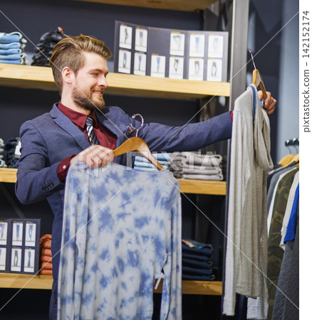 Businessman, clothes and boutique for comparing, shopping and choice for browsing, clothing rack and sale. Retail, consumer and purchase for casual outfit, buying and discount in hangers at the mall Businessman, clothes and boutique for comparing, shopping and choice for browsing, clothing rack and sale. Retail, consumer and purchase for casual outfit, buying and discount in hangers at the mall 142152174