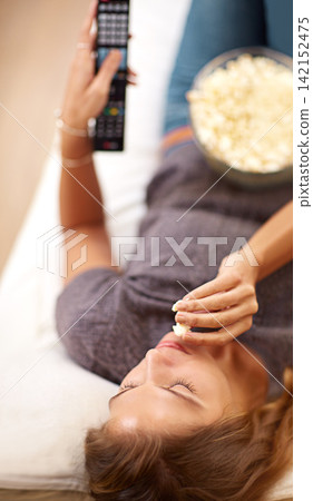 Woman, sofa and popcorn with remote and relax in home, food and watching on weekend. Subscription, entertainment and snack for movie or show, streaming and living room on couch for self care Woman, sofa and popcorn with remote and relax in home, food and watching on weekend. Subscription, entertainment and snack for movie or show, streaming and living room on couch for self care 142152475