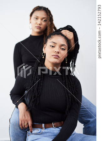 Sisters, portrait and fashion in studio, chair and style bonding on white background. Women, pride and cool care for relationship on backdrop, casual outfit and twins matching for trend or braids 142152793