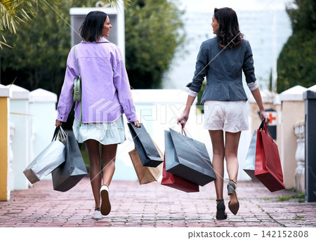 Girl, friends and shopping bag in city with back, walking and happy for deal, discount and retail sale. Women, together and smile with fashion, product and package for customer experience in park Girl, friends and shopping bag in city with back, walking and happy for deal, discount and retail sale. Women, together and smile with fashion, product and package for customer experience in park 142152808