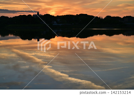 The sunrise reflected on the surface of the river The sunrise reflected on the surface of the river 142153214