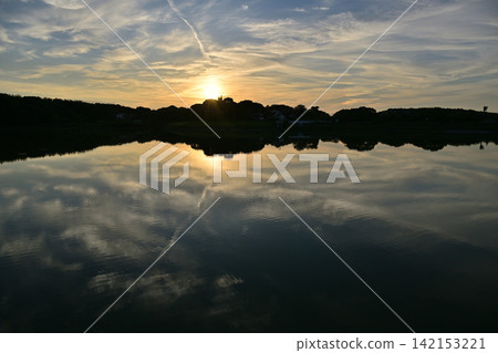 Morning glow reflected on the water surface Morning glow reflected on the water surface 142153221