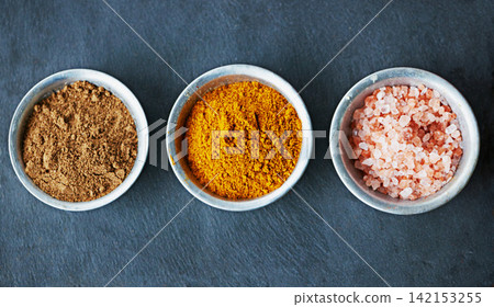 Top view, spices in bowl and ingredients for food, culinary and flavor with powder or ground seasoning for cooking background. Sea salt, cinnamon and turmeric for meal and cuisine with catering Top view, spices in bowl and ingredients for food, culinary and flavor with powder or ground seasoning for cooking background. Sea salt, cinnamon and turmeric for meal and cuisine with catering 142153255