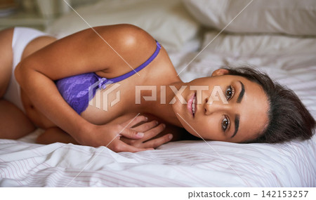 Woman, underwear and portrait on bed with bra for confidence, sensual and body in house bedroom. Colombia model, lingerie and serious in home with bedding for art decor, alluring and attractive 142153257