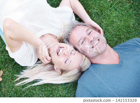 Mature, couple and laugh on grass or married connection for travel holiday on anniversary, date or bonding. Man, woman and from above or laughing for funny joke with humor together, field or summer 142153329