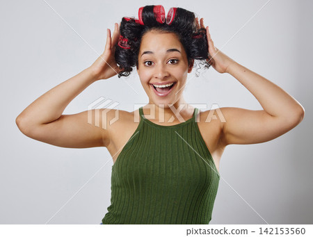 Hair, portrait and excited woman in studio with roller, beauty or natural curly styling on grey background. Haircare, face and happy model with DIY curling tool for makeover, change or transformation Hair, portrait and excited woman in studio with roller, beauty or natural curly styling on grey background. Haircare, face and happy model with DIY curling tool for makeover, change or transformation 142153560