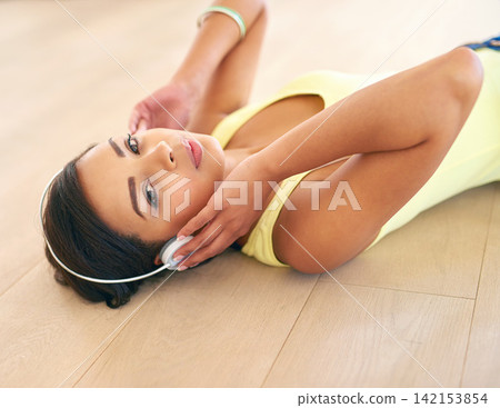 Portrait, relax or woman on floor in headphones for listening to music, radio or podcast in house or home. Face, online subscription or girl laying on ground streaming with playlist for calm audio 142153854