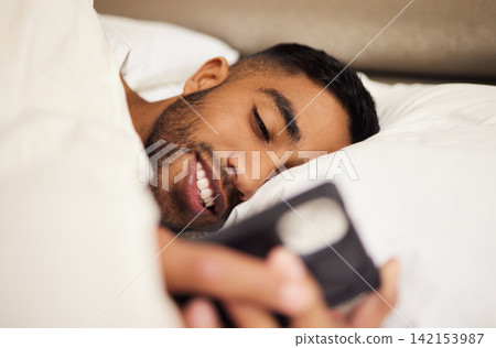 Man, bed and tired or phone for internet in home, pillow and network to scroll on social media. Male person, bedroom and reading on website, blanket and app for communication or chat in apartment Man, bed and tired or phone for internet in home, pillow and network to scroll on social media. Male person, bedroom and reading on website, blanket and app for communication or chat in apartment 142153987
